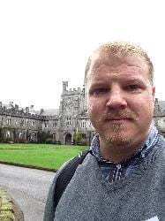 Headshot of Daniel Joesten standing in front of a castle.