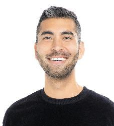Headshot of Anthony, wearing a black t-shirt and big smile, against a white backdrop.